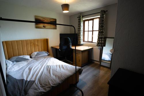 Schlafzimmer mit einem Bett, einem Schreibtisch und einem Fenster in der Unterkunft Sevenoaks Guest House in Trimley Heath