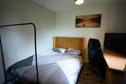 Schlafzimmer mit einem Bett und einem Schreibtisch mit einem Computer in der Unterkunft Sevenoaks Guest House in Trimley Heath