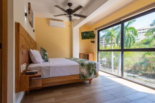 Un dormitorio con una cama y una ventana grande. en Condominios Brisas del Mar, en Santa Cruz Huatulco