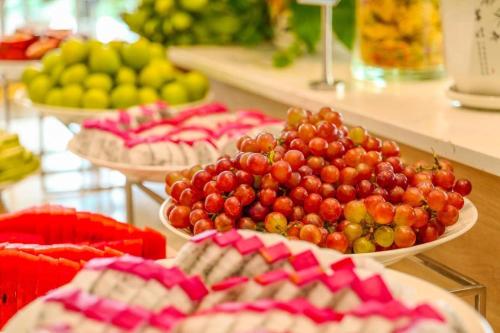 a buffet with plates of grapes and other fruits at THE CAM RANH RESORT at Bai Dai in Cam Ranh