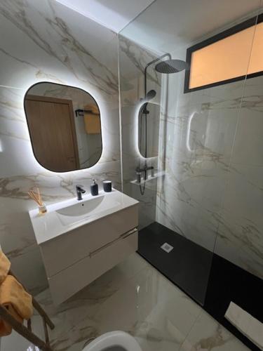 ein Badezimmer mit einem Waschbecken, einem Spiegel und einem WC in der Unterkunft My Home in Braga