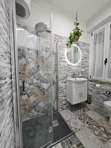 y baño con ducha y lavamanos. en La suite (Sole), en Lido di Pomposa