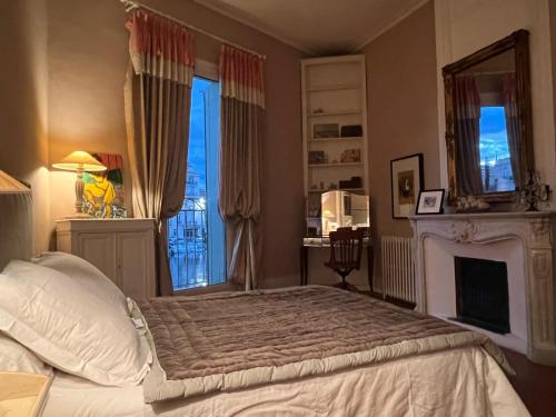 - une chambre avec un lit, une cheminée et une fenêtre dans l'établissement Maison de charme à Sète, à Sète