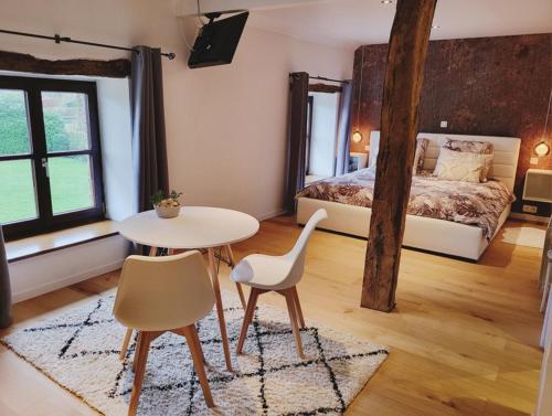 sypialnia z łóżkiem, stołem i krzesłami w obiekcie L'Essentiel bis w mieście Francorchamps