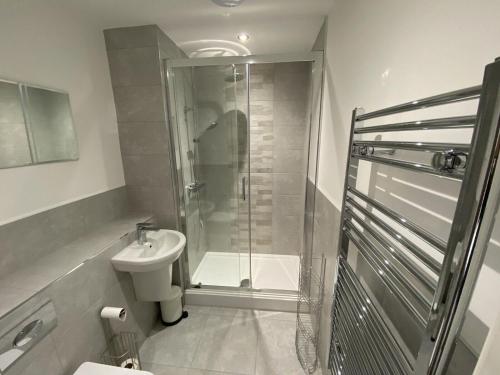 a bathroom with a shower and a toilet and a sink at The Idyllic City Centre Apartment & Free Parking in Sheffield