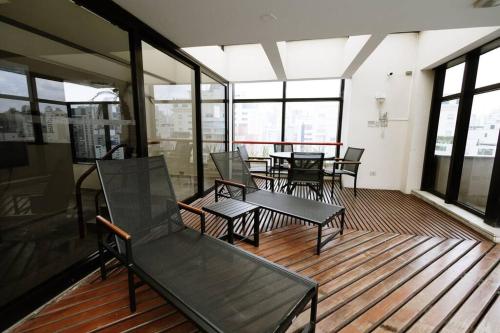 an empty room with chairs and tables and windows at Apart-hotel 1804 - Le Premier Suítes Jardim Paulista in Sao Paulo