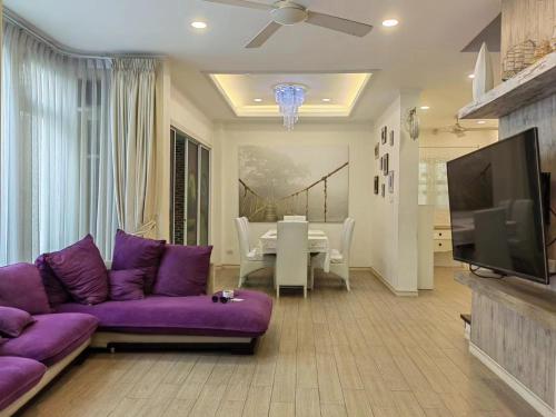 ジョムティエンビーチにある暂停-中天海滩的私人别墅のリビングルーム(紫色のソファ、テレビ付)