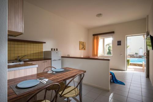 a kitchen with a table and some chairs in it at Meropi Hotel & Apartments in Malia