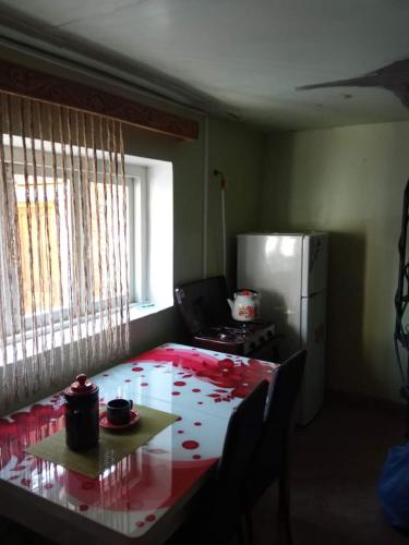 Buba في Oni: مطبخ مع طاولة مع قماش الطاولة الحمراء