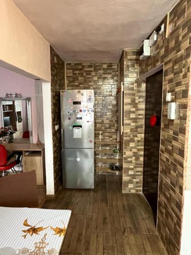 una cucina con frigorifero e muro di mattoni di Apartament IOANA a Deva