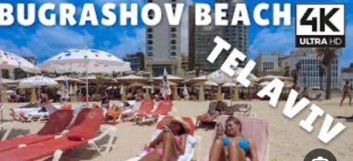 a poster for a beach with people sitting on chairs and umbrellas at סוויטה בוגרשוב על הים in Tel Aviv