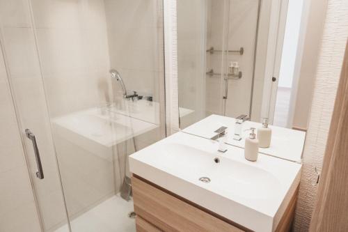 uma casa de banho branca com um lavatório e um chuveiro em Biasa Holidays em Torrox Costa