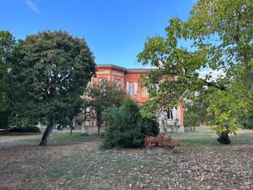 een oranje gebouw met bomen ervoor bij Maison familiale - 11 personnes - Labège in Labège