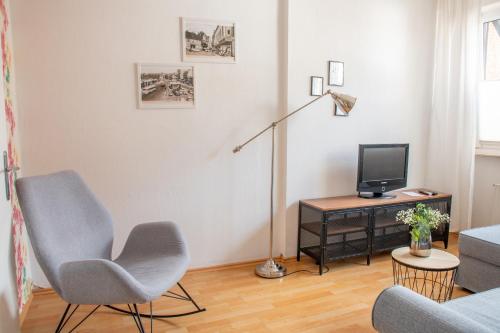 a living room with a chair and a television at Ferienwohnung im Herzen von Itzehoe mit eigenem Eingang in Itzehoe