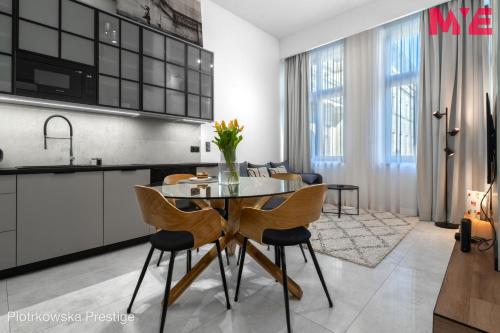 a kitchen and dining room with a table and chairs at MYE Apartments - Piotrkowska 44 in Łódź