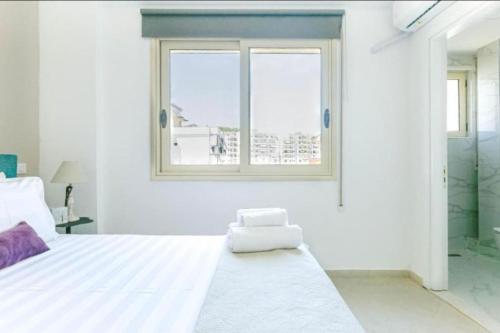 a white bedroom with a large bed and a window at Luxury Suite 3 in Himara in Himare