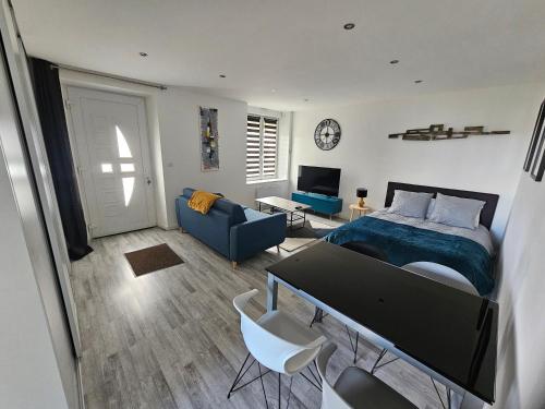 une chambre avec un lit et un salon dans l'établissement F2 neuf tout confort proche Epinal/ lac de Bouzey, à Uxegney