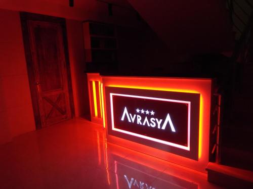 a neon sign that saysyssiya in a dark room at Avrasya Hotel in Baku