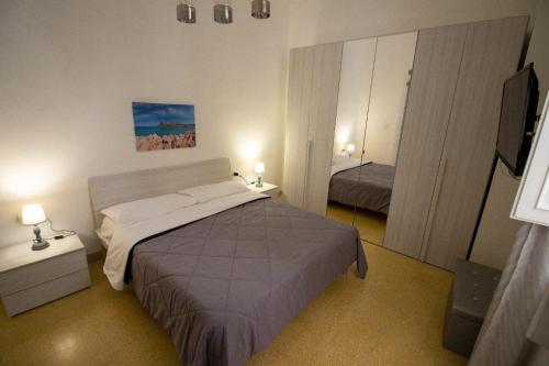 um quarto com uma cama e uma televisão em Attracco Apartment em Trapani