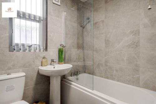 y baño con lavabo, aseo y bañera. en Large 3 bedroom sleeps-7/Gartson/Liverpool, en Liverpool