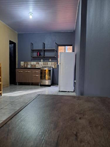 an empty kitchen with a refrigerator in a room at Hummingbird Hostel in Ciudad del Este