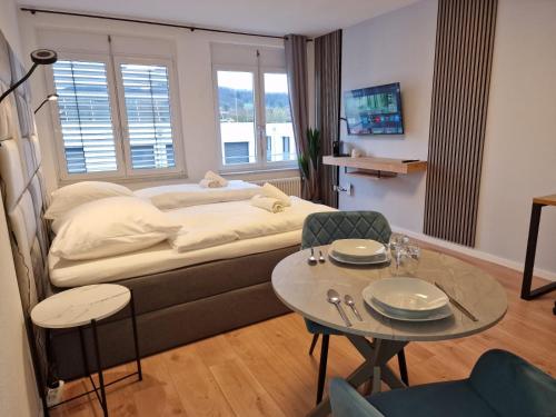 sala de estar con cama y mesa con sillas en RANGE Gemütliches Apartment für 2 Personen mit WLAN und TV, en Fellbach