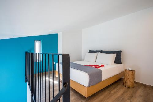 a bedroom with a bed and a blue wall at Meropi Hotel & Apartments in Malia