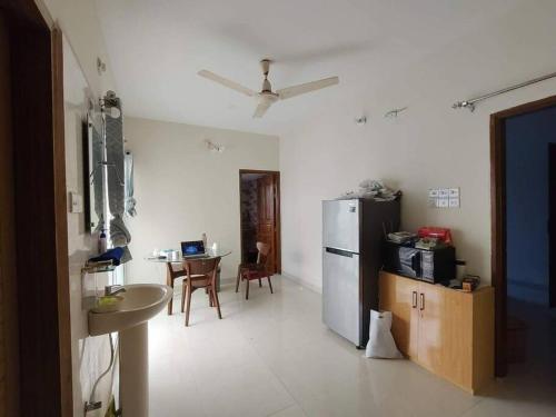 a kitchen with a refrigerator and a table in it at Cozy Stay in New Flat, Dhaka, BD in Dhaka
