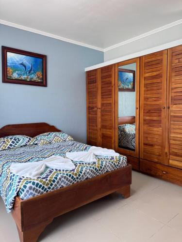 a bedroom with a bed and a wooden cabinet at Hotel La Fiore de Bahia in Uvita