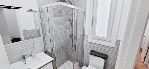 een badkamer met een glazen douche en een wastafel bij Comodidad cerca de la playa.. a un paso de todo! in A Coruña