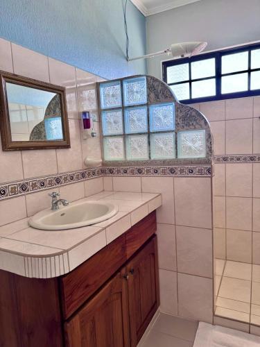 a bathroom with a sink and a mirror at Hotel La Fiore de Bahia in Uvita