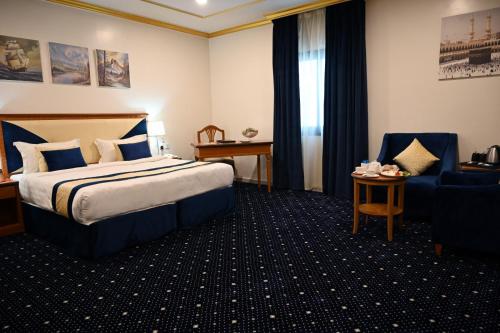 a hotel room with a bed and a chair at Amjad Al Deafah Hotel in Mecca