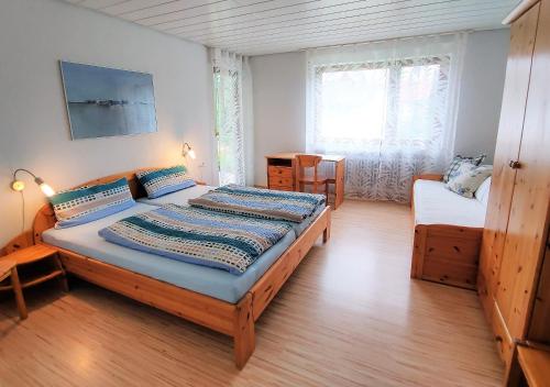 ein Schlafzimmer mit einem großen Bett und einem Fenster in der Unterkunft BodenSEE Apartments Daisendorf nahe Meersburg in Daisendorf