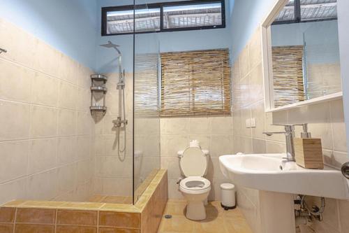 a bathroom with a shower and a toilet and a sink at Surf Salvacion in San Felipe de Puerto Plata