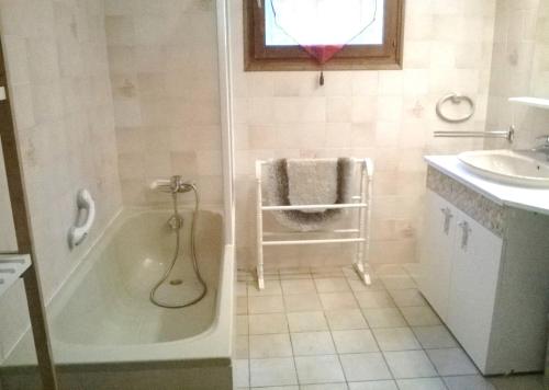 une salle de bain avec une baignoire et un lavabo dans l'établissement LE GITE D'HENRI 1- Maison individuelle -3 chambres, à Chorges