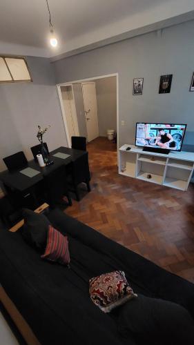 uma sala de estar com um sofá e uma televisão em Tucuman y Carlos Pellegrini em Buenos Aires