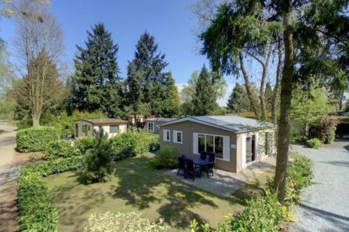 a tiny house in the middle of a yard at Mooi chalet op prachtige plek in het groen in Voorthuizen