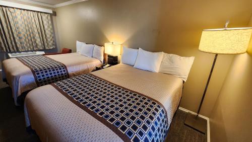 a hotel room with two beds and a lamp at Welcome Everett Inn in Everett