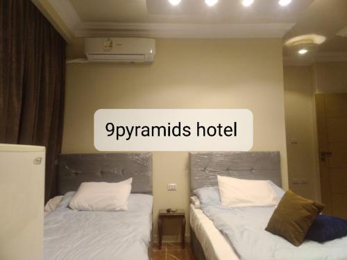 two beds in a room with the words gymnrats hotel at 9pyramids hotel in Cairo