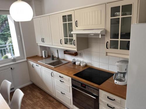 a kitchen with white cabinets and a sink at Apartament Stay with Gdynia in Gdynia
