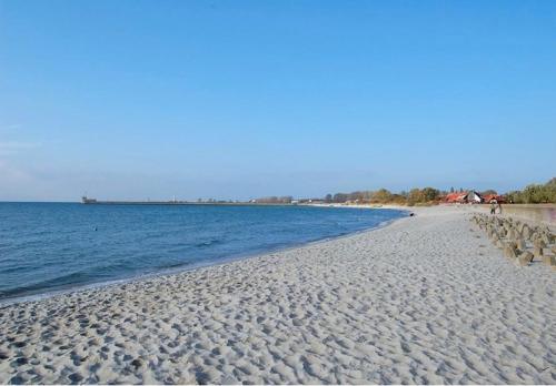 piaszczystą plażę z leżakami i oceanem w obiekcie GRECOS HOLIDAY w mieście Hel