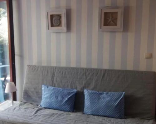 a bed with two blue pillows in a room at GRECOS HOLIDAY in Hel