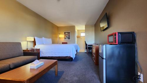 a hotel room with a bed and a refrigerator at Welcome Everett Inn in Everett