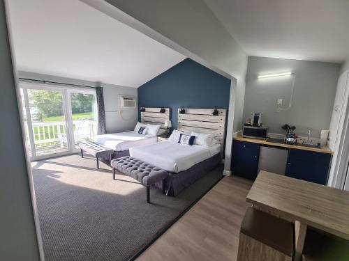 1 dormitorio con 2 camas, escritorio y mesa en Smuggler's Cove Inn en Boothbay