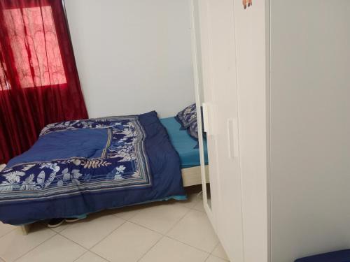 Family Studio Apartment في الشارقة: غرفة نوم مع سرير مع لحاف أزرق