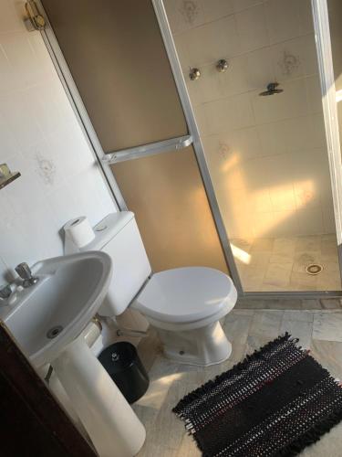 a bathroom with a toilet and a sink and a shower at Pousada Solar Colonial in Iguape