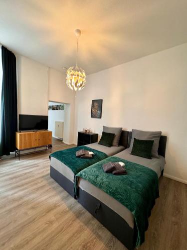 a bedroom with two beds and a couch and a chandelier at Wohnung im Zentrum 2 in Magdeburg