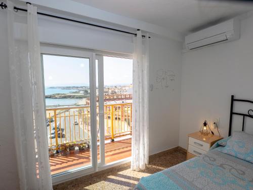 a bedroom with a balcony with a view of the ocean at Playa el Clot - Vinaròs in Vinaròs
