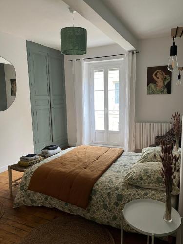 une chambre avec un grand lit et une fenêtre dans l'établissement La Buissonnière Maison Authentique Au Cœur du Village, à Cadouin