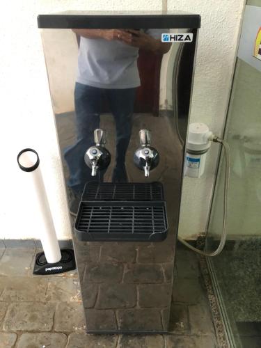 a man standing in a shower in a bathroom at Studio 304 ao lado do Shopping e Metrô in Brasilia